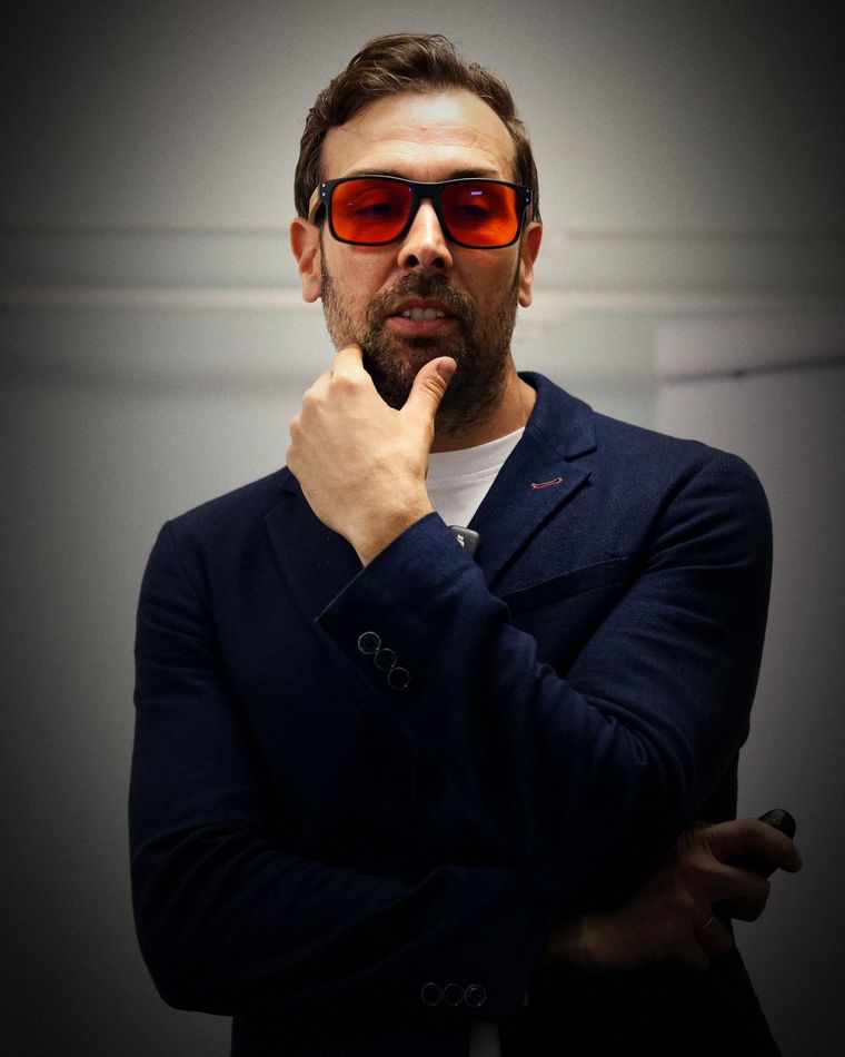 Jose M Bermejo in orange lenses, hand on his chin, listening
